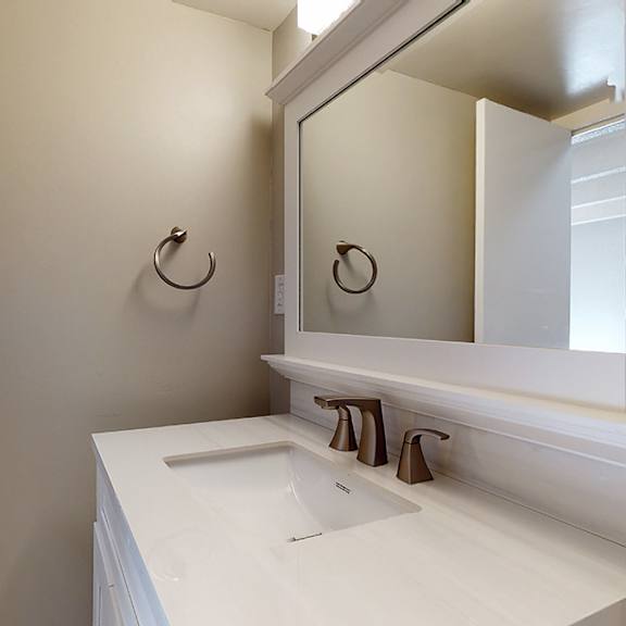 a white bathroom sink with a mirror above it.