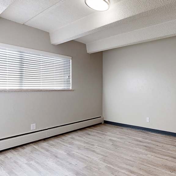 a room with wooden flooring and white walls.