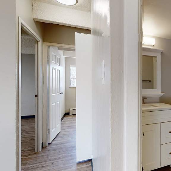 a white bathroom with a toilet, sink, and mirror.