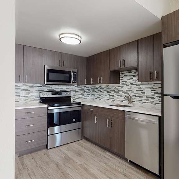 a modern kitchen with a stainless steel refrigerator and microwave.