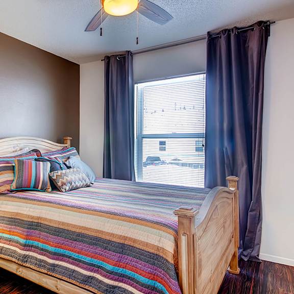 a bedroom with a bed, nightstand, and window.