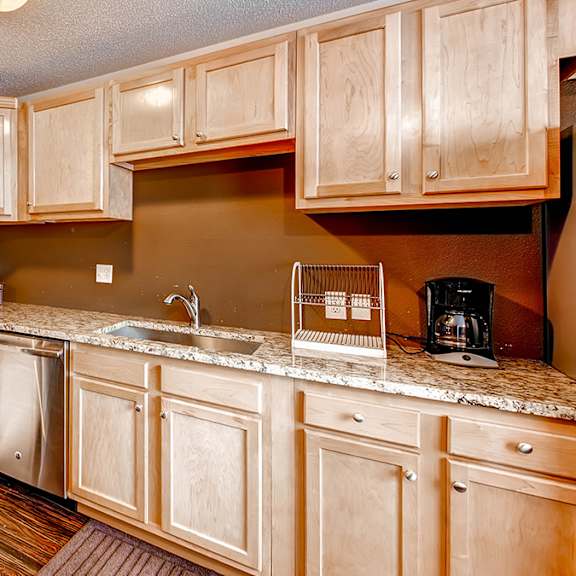 a kitchen with wooden cabinets and a stainless steel oven.
