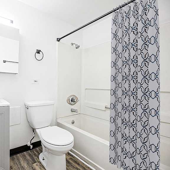a white bathroom with a toilet, sink, and shower.