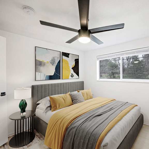 a bedroom with a bed, a ceiling fan, and a window.