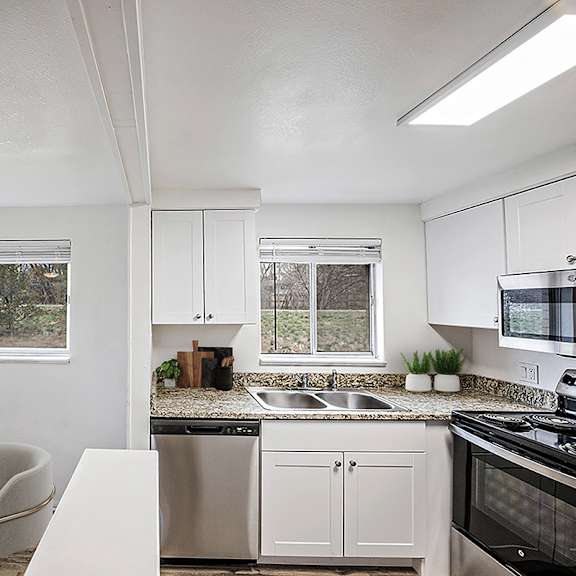 a white kitchen with a table and chairs.