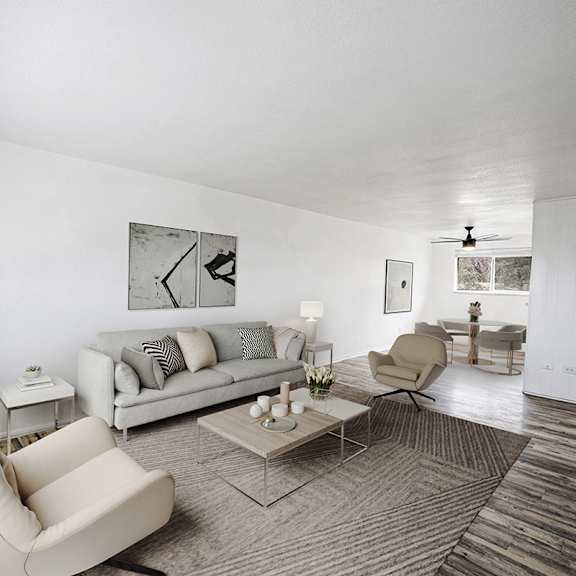 a living room with a couch, chair, and potted plant.