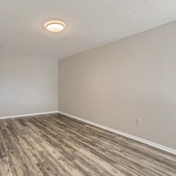 a room with wooden flooring and white walls.