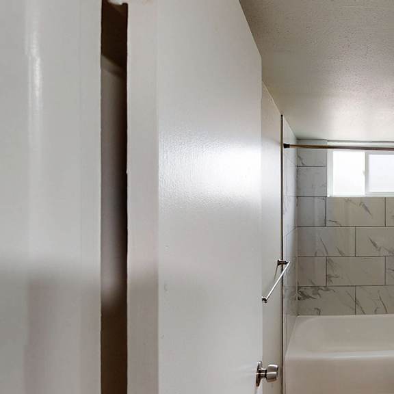 a white bathroom with a tub, toilet, and sink.