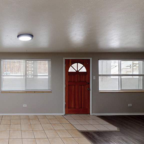 a room with a red door and a window with blinds.