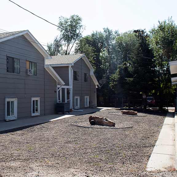 a gravel courtyard is surrounded by two-story houses.