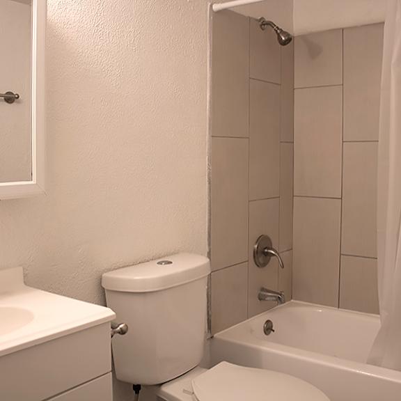 a white bathroom with a toilet, sink, and bathtub.