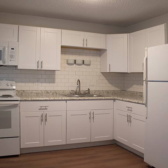 a kitchen with white cabinets and appliances.