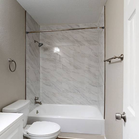 a white bathroom with a marble shower.