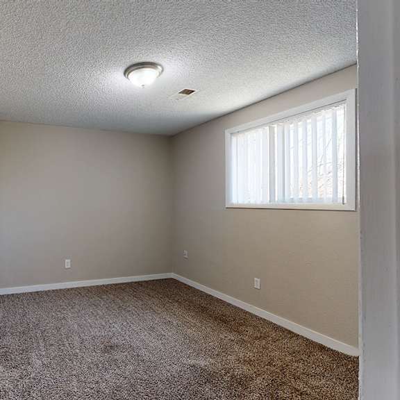 a room with a carpeted floor and a door on the left.