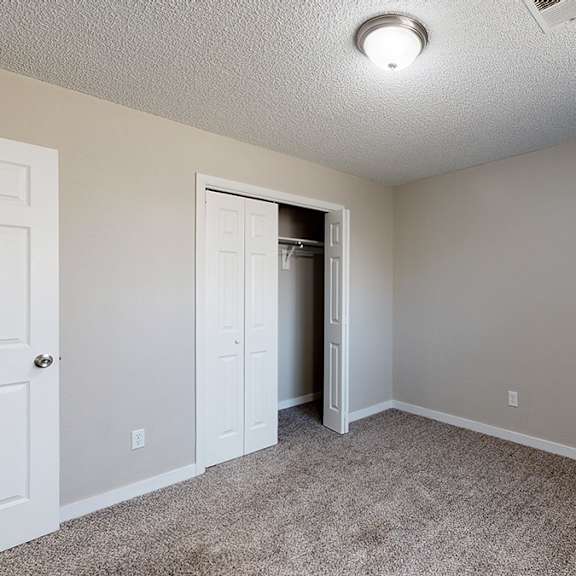 a room with a white door and a carpeted floor.