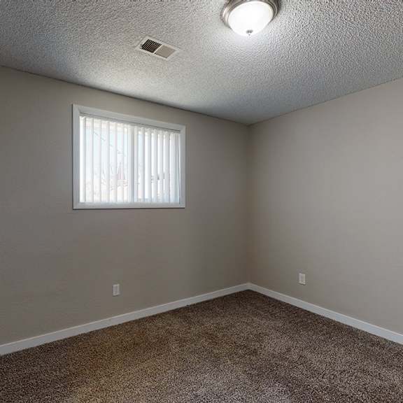 a room with a window and carpeted floor.