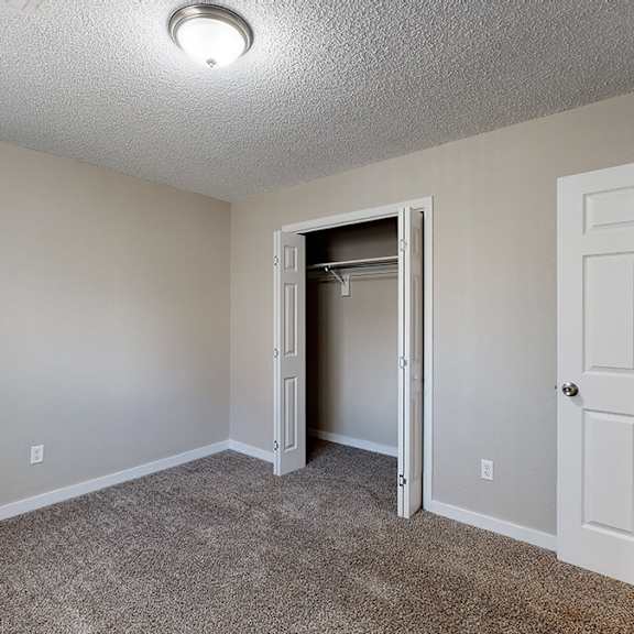 a room with a white door and a carpeted floor.