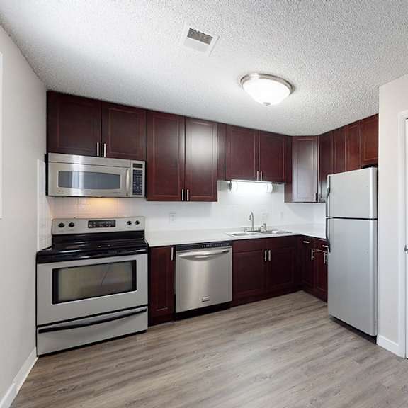 a kitchen with a white refrigerator and wooden cabinets.