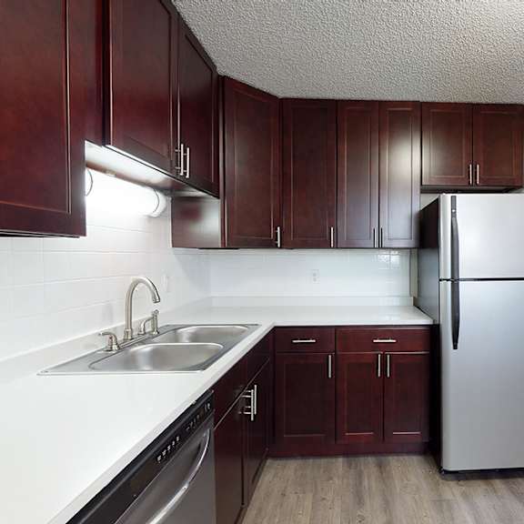 a kitchen with brown cabinets and a white fridge.