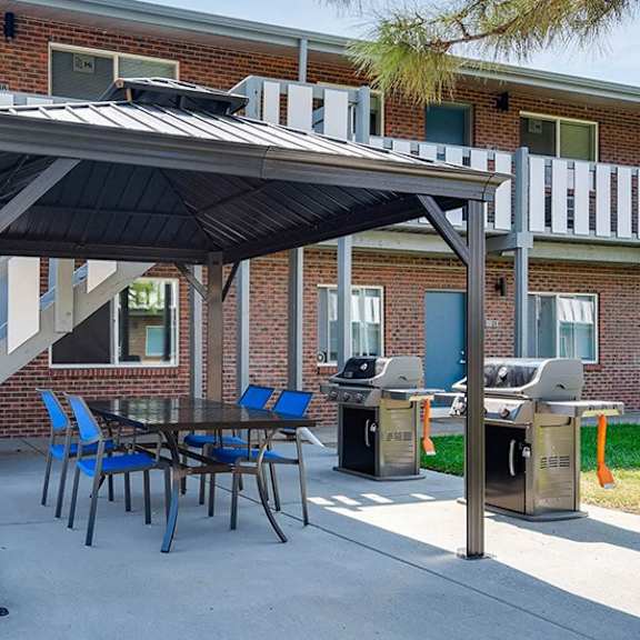 a patio with a table and chairs under a roof.