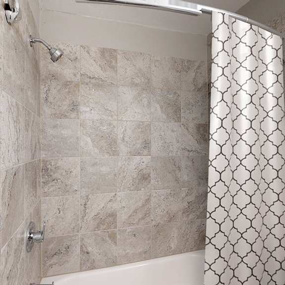 a shower area with a tile floor and a shower curtain.