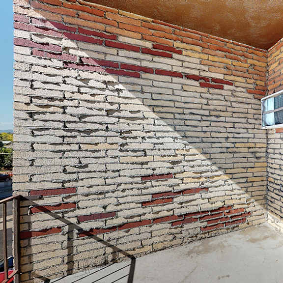 a brick wall with a window and air conditioner.
