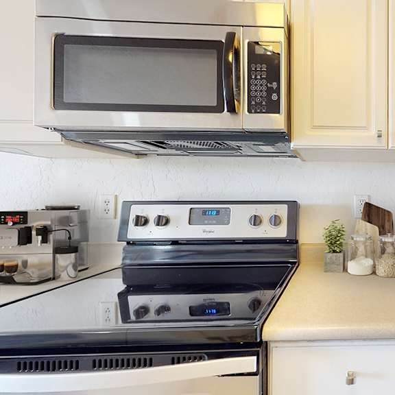 a kitchen with a stove, microwave, and oven.