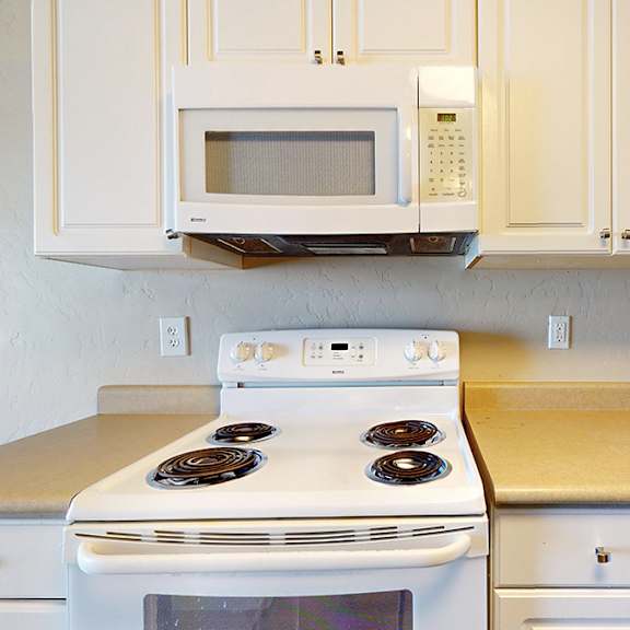 a white stove and microwave in a kitchen.