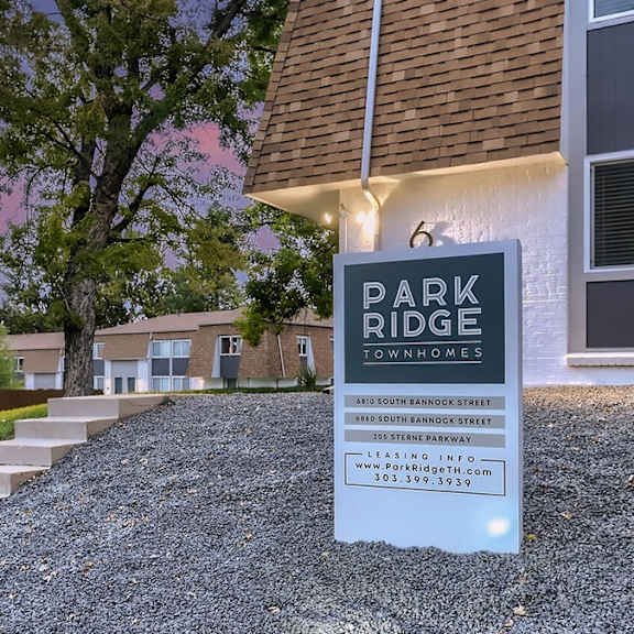 a sign for park ridge townhomes stands in front of a building.