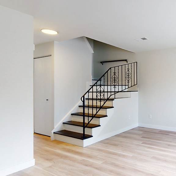 a room with a staircase and wooden flooring.
