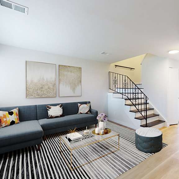 a living room with a blue couch and a glass coffee table.