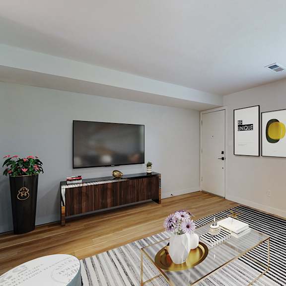 a living room with a flat screen tv, a coffee table, and a couch.
