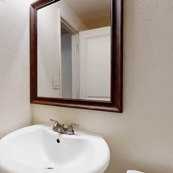 a white sink in a bathroom with a mirror above it.