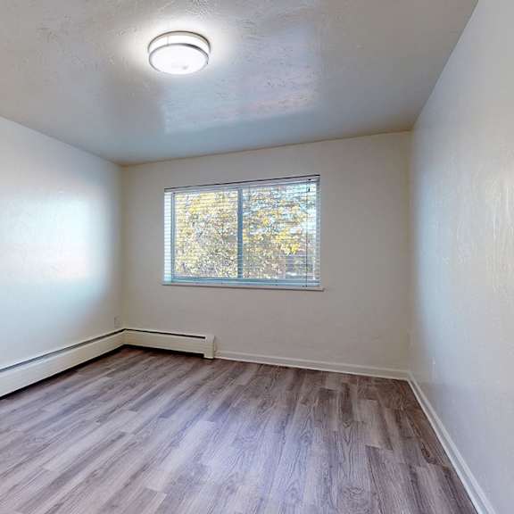 a room with a window and wooden flooring.