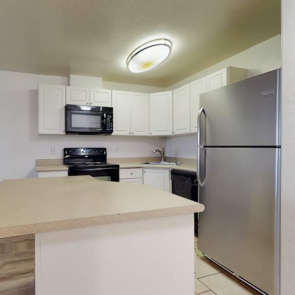 a kitchen with a refrigerator, microwave, and oven.