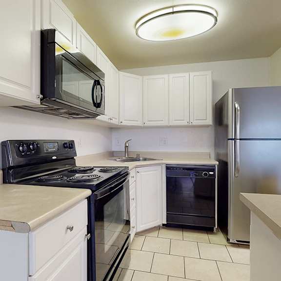 a kitchen with white cabinets and a black stove top oven.