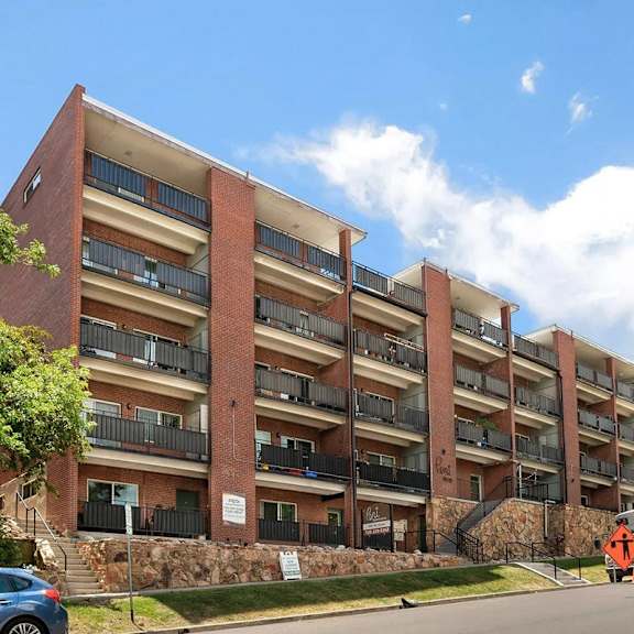 a large red brick building with a blue car parked in front.