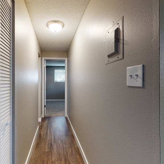 a long hallway with a door at the end.