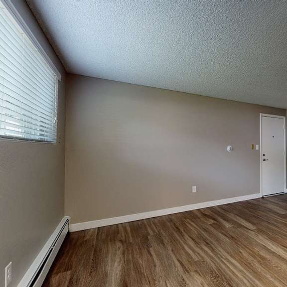 a room with wooden flooring and a white door.