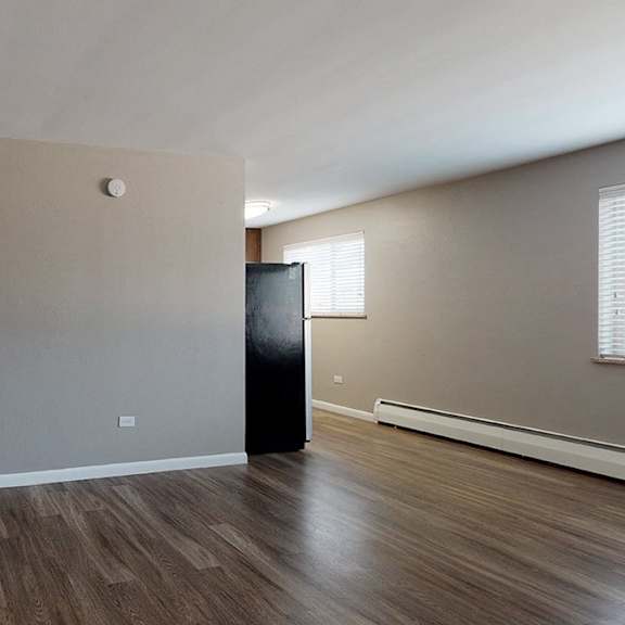 a room with a wooden floor and a black object in it.