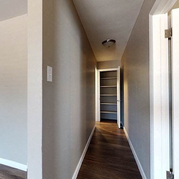 a long hallway with a door on the right.