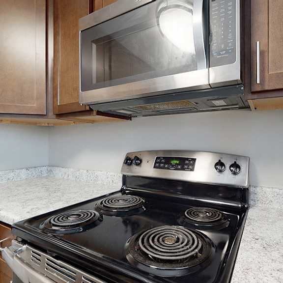 a modern kitchen with a stove top oven and microwave above it.