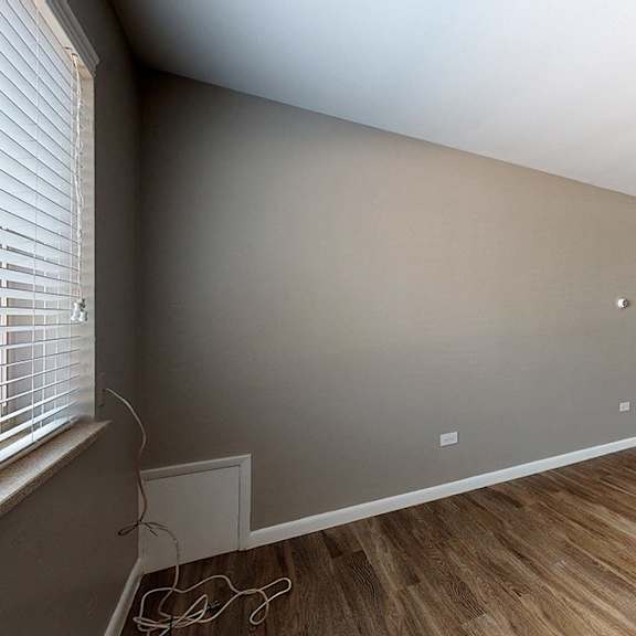 a room with wooden floors and a white door.