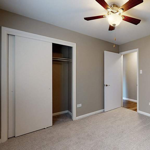 a room with a ceiling fan and two doors.