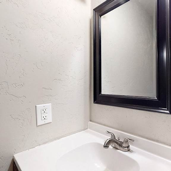 a white sink under a mirror in a bathroom.