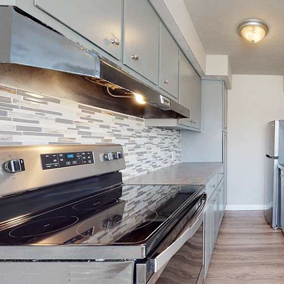 a modern kitchen with a stove top oven and a refrigerator.