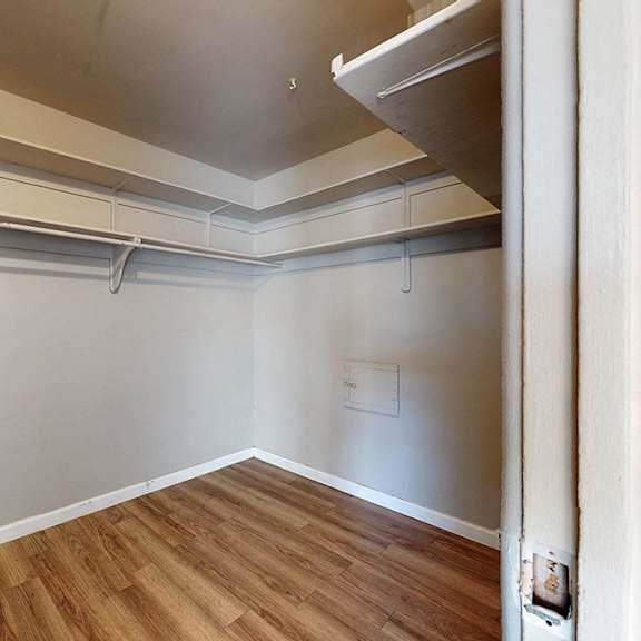 a room with a white wall and a wooden floor.