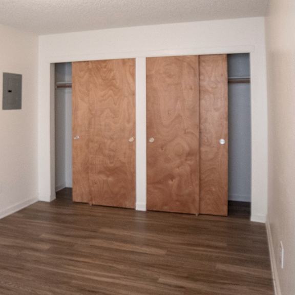 a room with wooden floors and a wall-mounted thermostat.