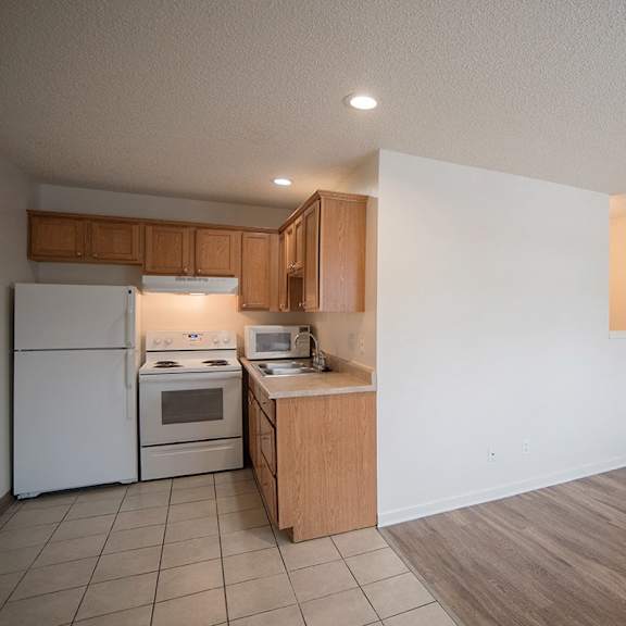a kitchen with white appliances and wooden cabinets.