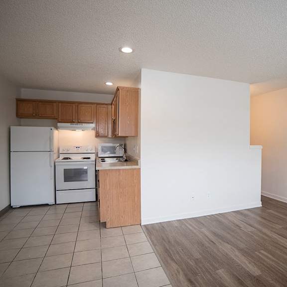 a kitchen with a refrigerator, oven, and sink.